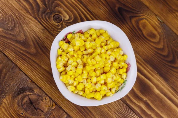 Ahşap masa üzerinde bir kase konserve mısır