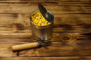 Açık konserve mısır ve ahşap masa üzerinde açacağı konserve
