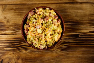 Sosis, bezelye, havuç ve soğan ahşap masa üzerinde mayonez salatası