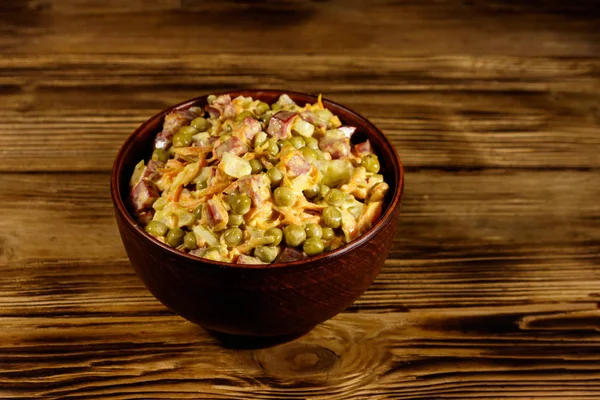 Salată de maioneză cu cârnați, mazăre verde, morcov și ceapă pe masă de lemn — Fotografie, imagine de stoc