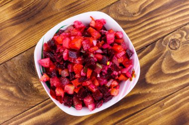 Pancar, havuç, patates, soğan ve ahşap masada salatalık turşusu ile geleneksel Rus salatası vinaigrette. Üstte görüntü