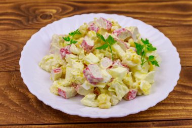 Yengeç saplı salata, tatlı mısır, Çin lahanası, yumurta ve mayonez ahşap masada.