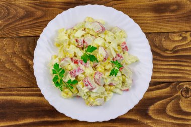 Yengeç saplı salata, tatlı mısır, Çin lahanası, yumurta ve mayonez ahşap masada.