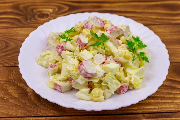 Yengeç saplı salata, tatlı mısır, Çin lahanası, yumurta ve mayonez ahşap masada.