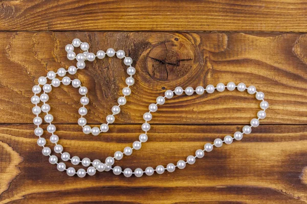 Collar de perlas sobre fondo de madera. Vista superior — Foto de Stock