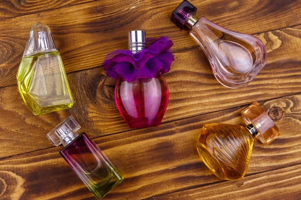 Différentes bouteilles de parfum sur le fond en bois. Vue du dessus — Photo