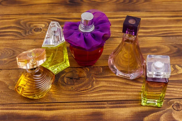 Different bottles of perfume on the wooden background — Stock Photo, Image