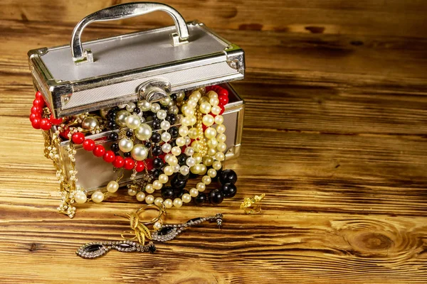 Jewelry box full of jewelry and accessories on wooden background — Stock Photo, Image