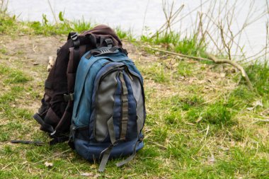 Nehir kıyısında iki turistik sırt çantası. Yürüyüş konsepti