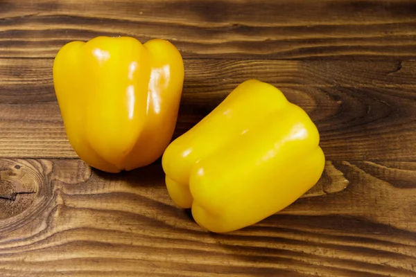 Pimentos amarelos maduros frescos na mesa de madeira — Fotografia de Stock