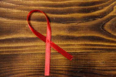 Ahşap arka planda kırmızı AIDS şerit