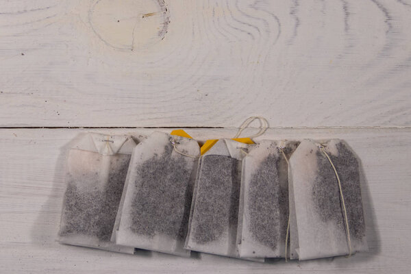 Пакеты чая на белом деревянном столе. Вид сверху
