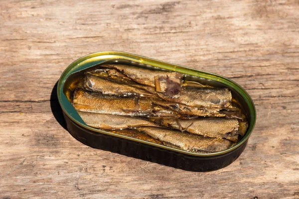 Lata abierta de espadines sobre mesa de madera rústica — Foto de Stock