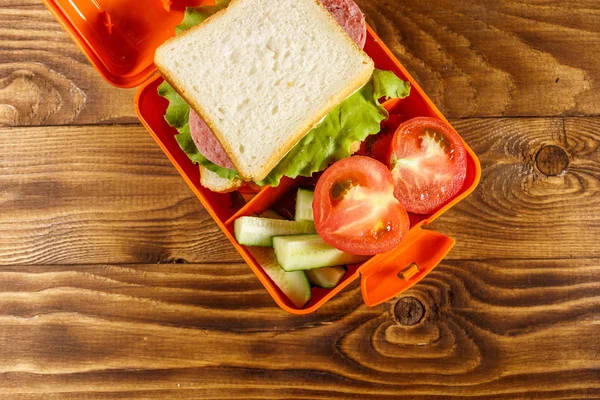Pranzo scolastico con panino e verdure fresche sul tavolo di legno. Vista dall'alto — Foto Stock