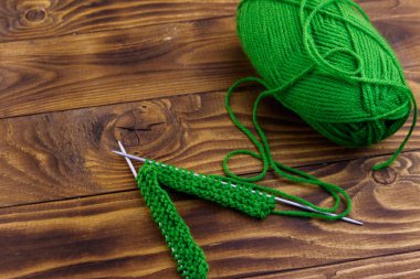 Ahşap masa üzerinde örgü ile iplik ve örgü iğneleri topu