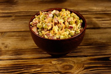 Sosis, bezelye, havuç ve soğan ahşap masa üzerinde mayonez salatası