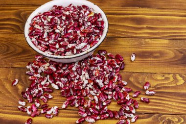 Ahşap masada beyaz eski emaye kase ham böbrek çekirdekleri 