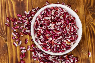 Ahşap masada beyaz eski emaye kase ham böbrek çekirdekleri 