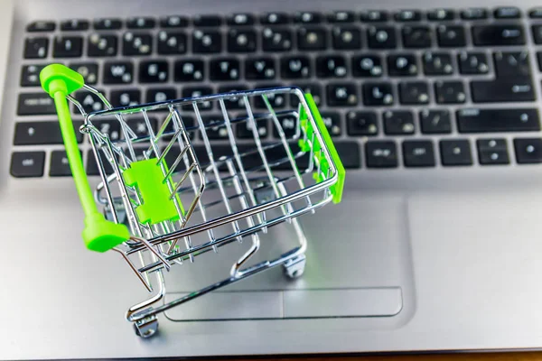 Concepto de compras online. Pequeño carrito de compras en el teclado portátil —  Fotos de Stock