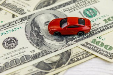 Amerikan doları ve beyaz ahşap arka plan üzerinde minyatür araba modeli. Araç kredisi konsepti