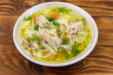 Tahta masada erişte ve sebze ile tavuk çorbası