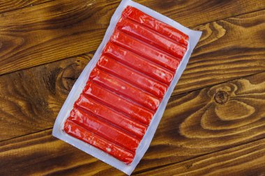 Yengeç, tahta masanın üzerindeki vakum paketine yapışır. Üstte görüntü