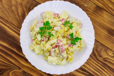 Yengeç saplı salata, tatlı mısır, Çin lahanası, yumurta ve mayonez ahşap masada.