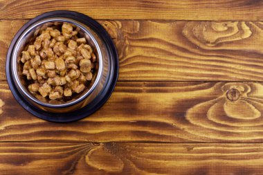 Ahşap zemin üzerinde metal kase kedi veya köpekler için konserve gıda. Üstte görüntü