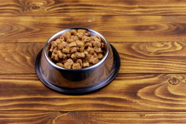 Ahşap zemin üzerinde metal kase kedi veya köpekler için konserve gıda