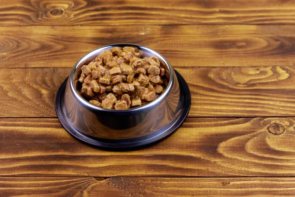 Ahşap zemin üzerinde metal kase kedi veya köpekler için konserve gıda