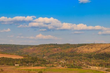 Mavi gökyüzü ve dağ tepelerinde renkli sonbahar ağaçları olan resimli sonbahar manzarası