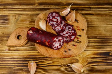 Tahta üzerinde dilimlenmiş salam sosisi. Üst görünüm