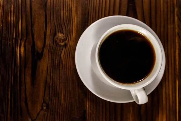 Uma chávena de café na mesa de madeira. Vista superior — Fotografia de Stock