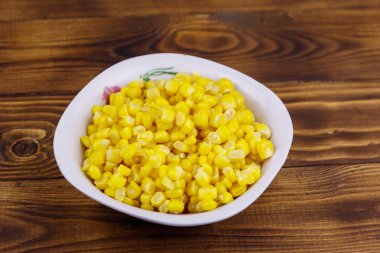 Ahşap masa üzerinde bir kase konserve mısır