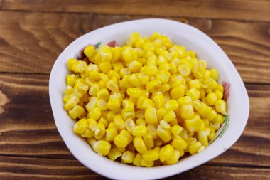 Ahşap masa üzerinde bir kase konserve mısır