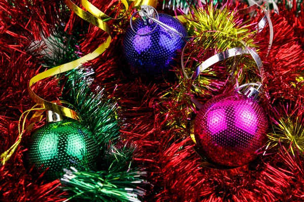 Рождественская композиция с рождественскими безделушками и разноцветной мишурой. Рождественские шары в яркой мишуре крупным планом — стоковое фото