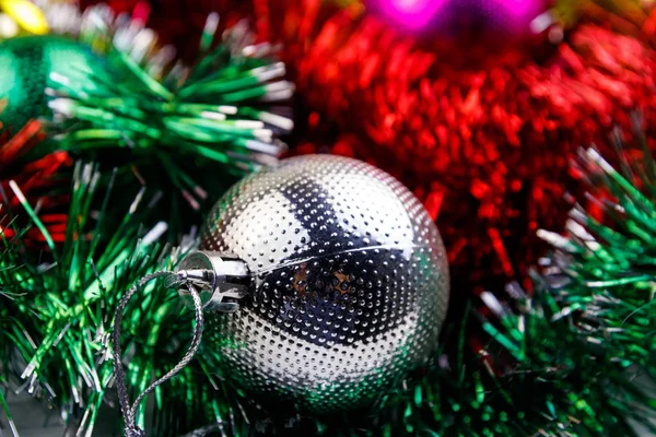 Kerstcompositie met kerstballen en veelkleurig knutselwerk. Kerstballen in helder tinsel close-up — Stockfoto