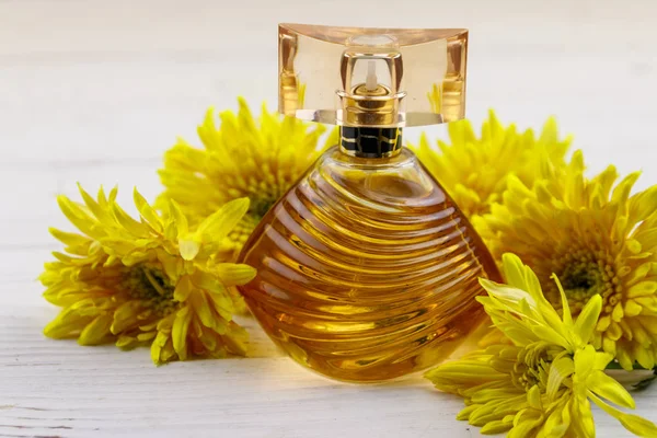 Women perfume with flowers on white wooden background — Stock Photo, Image