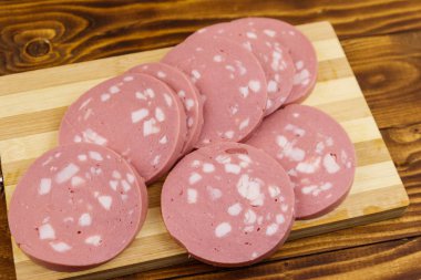 Ahşap masada dilimlenmiş haşlanmış sosis.