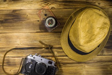 Ahşap arka plan üzerinde Pusula, şapka ve retro fotoğraf makinesi