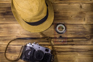 Ahşap arka plan üzerinde Pusula, şapka ve retro fotoğraf makinesi