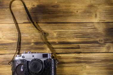 Ahşap arka planda deri kasa retro fotoğraf makinesi