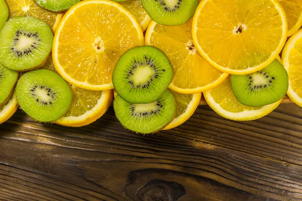 Нарізані ківі фрукти та апельсини на дерев'яному столі — стокове фото