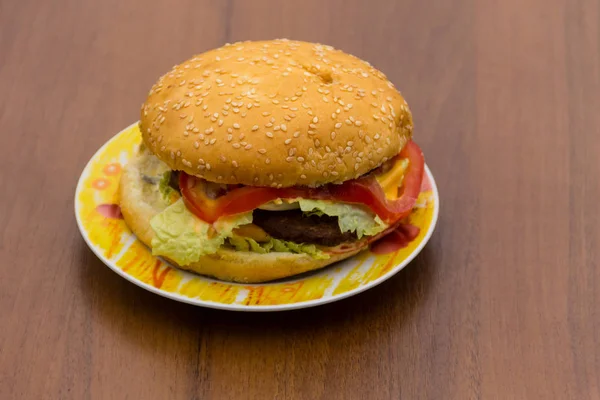 Delicioso hambúrguer ou sanduíche na placa na mesa de madeira — Fotografia de Stock
