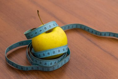 Tahta masada şerit ve yeşil elma ölçüyorum. Diyet ve sağlıklı yaşam tarzı kavramı