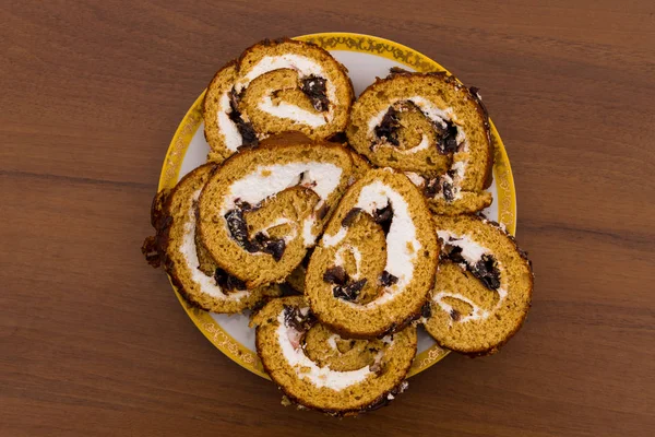 Fatias de bolo com poda em uma chapa na mesa de madeira — Fotografia de Stock