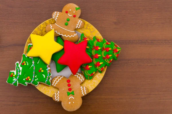 Talerz ze smacznymi ciasteczkami świątecznymi na drewnianym stole — Zdjęcie stockowe