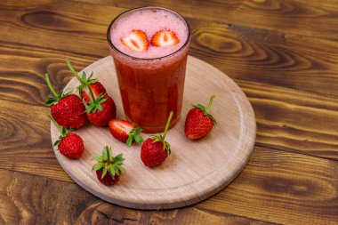 Tahta masada bir bardak taze çilekli smoothie.