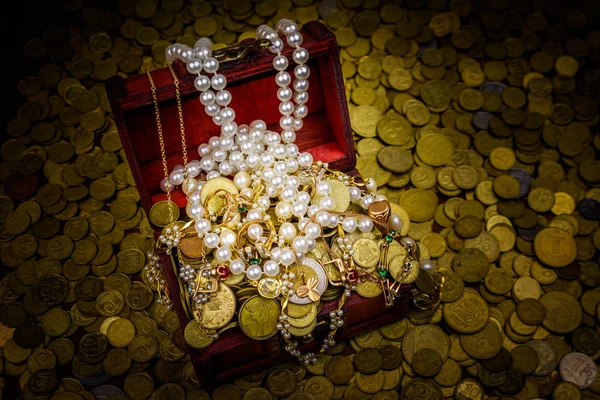 Cofre del tesoro vintage lleno de monedas de oro y joyas sobre un fondo de monedas de oro — Foto de Stock