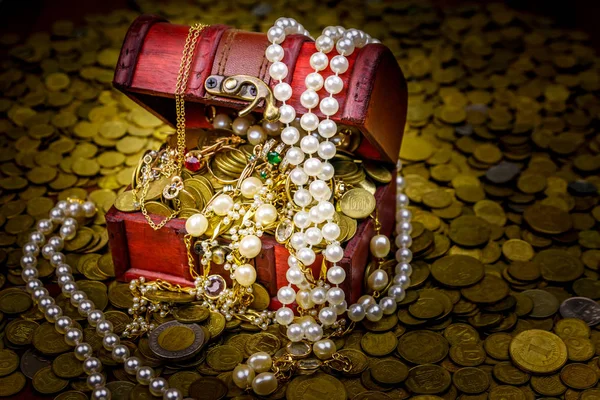 Altın sikke ve mücevherlerle dolu eski bir hazine sandığı.